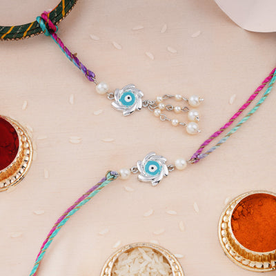 Estele Rhodium Plated Sudharshan Chakra Designer Rakhi Set for Bhaiya Bhabhi with Aqua-Colored Enamel, Pearls & Multi-Colored Silk Thread